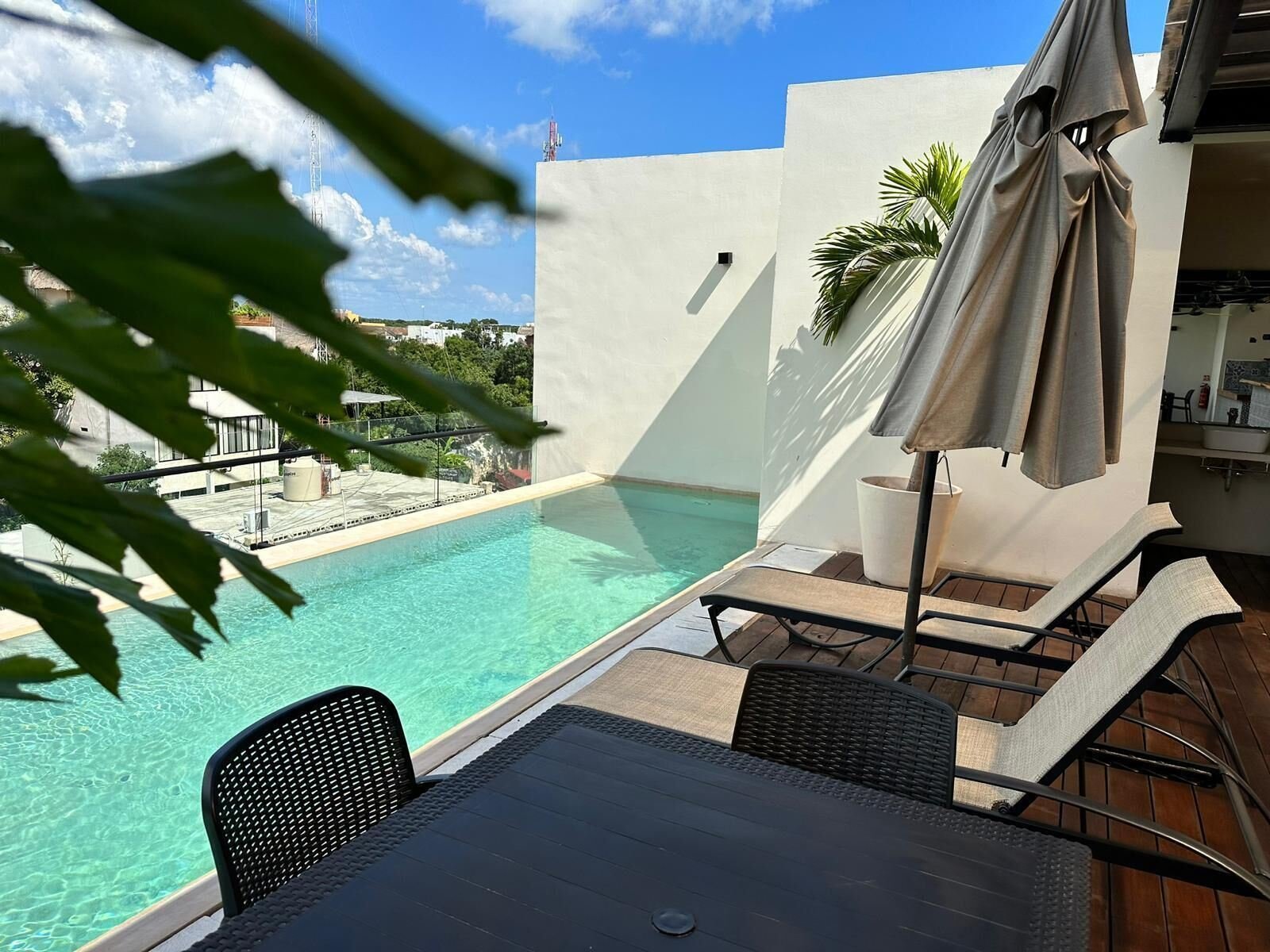 Moonshine Tulum Hotel: poolside table and chairs under an umbrella
